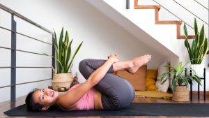 femme sur tapis de gym genoux sur ventre
