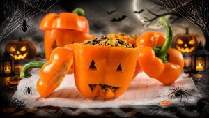 poivrons oranges coupes en visage de citrouille halloween