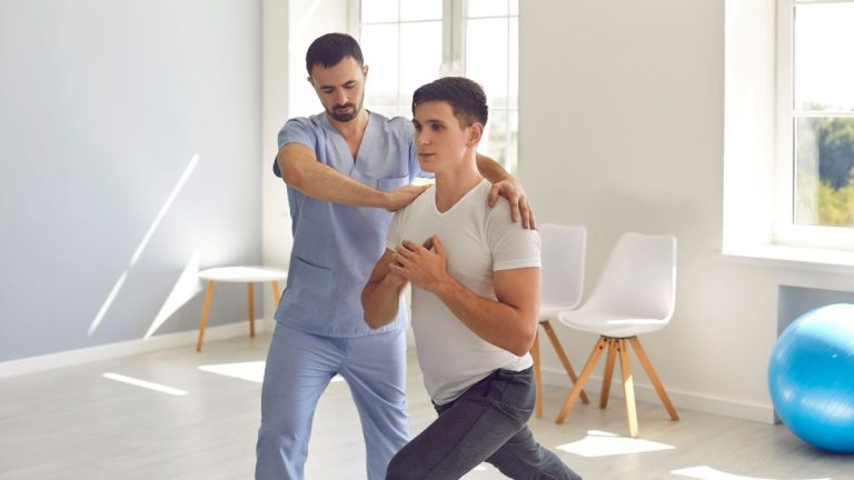 un soignant avec un homme faisant exercice en se tenant le coeur